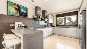 Stylish and functional kitchen with minimalist design, built-in appliances, and a large window bringing in plenty of natural light.