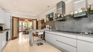 Stylish and functional kitchen with minimalist design, built-in appliances, and a large window bringing in plenty of natural light.