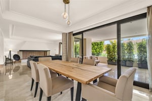 Open-plan dining and living area with marble floors and outdoor access in Marbella apartment
