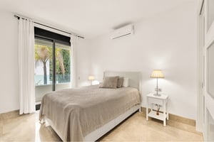 Bright double bedroom with garden view and modern air conditioning unit in Marbella apartment