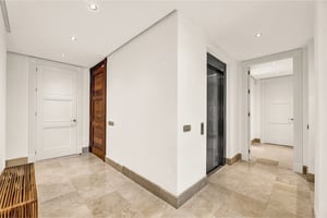 Elegant hallway with marble floors and private elevator access in upscale residence