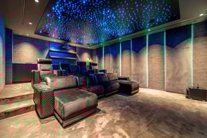 Private home cinema with plush tiered seating, starry ceiling lighting, and ambient wall lights for a cozy, immersive atmosphere.